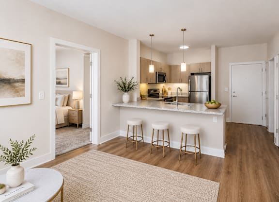 A kitchen with a bar stool and a fridge.