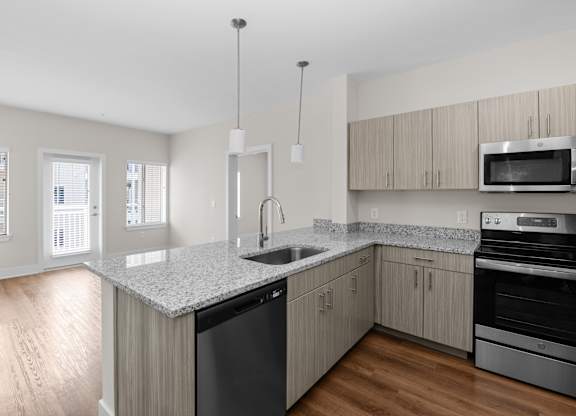 A kitchen with a granite countertop and stainless steel appliances.