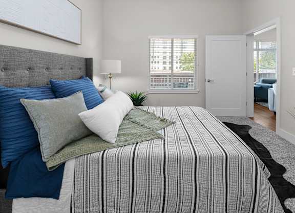 A bedroom with a large bed and a grey headboard.