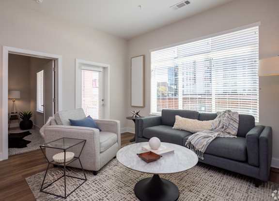 Modern living room with sofa and chair at NOVI at Concord.