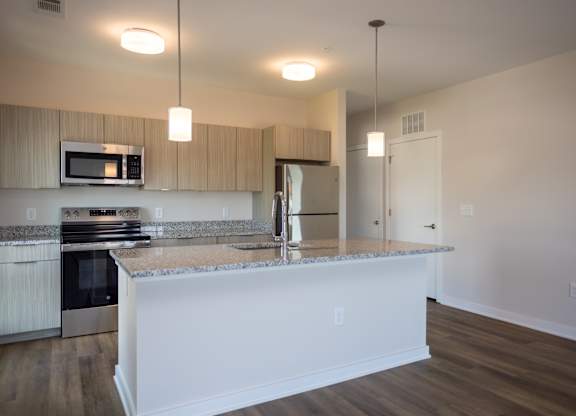 A kitchen with granite countertops and white cabinets.