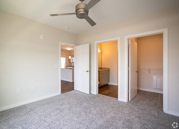 A room with a ceiling fan and carpeted floor.