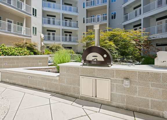 A stone bench with a sculpture of a face on it sits in front of a building.