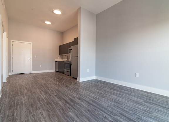 A kitchen area with a refrigerator, sink, and cabinets.