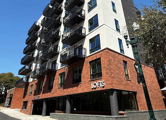 A tall building with a white top and a red base with the word "LOFIS" on it.
