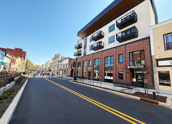 A street view with a building that has a sign that says "PILATES".