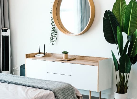 a bedroom with a mirror and a bed and a plant