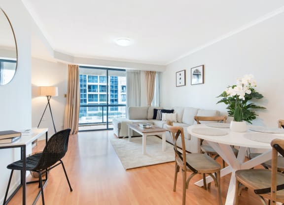 a living room and dining room with a table and chairs
