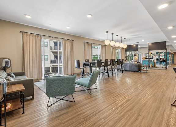 A spacious living room with wooden floors and a variety of seating options.