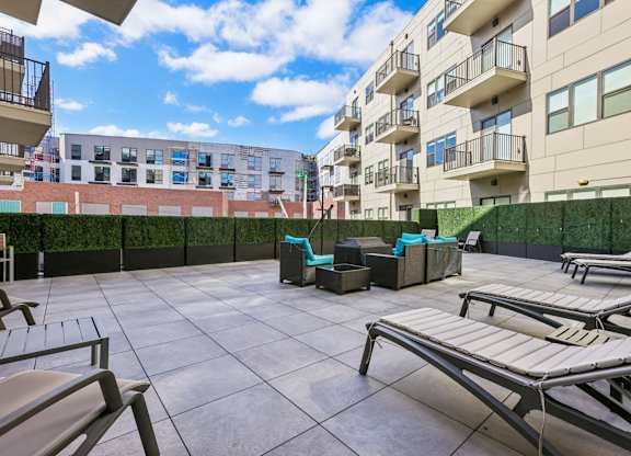 A sunny day at the rooftop pool with lounge chairs and a table.