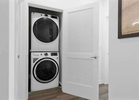 Two washing machines are stacked in a small laundry room at 10 N. Main Apartments, Wharton, NJ, 07885