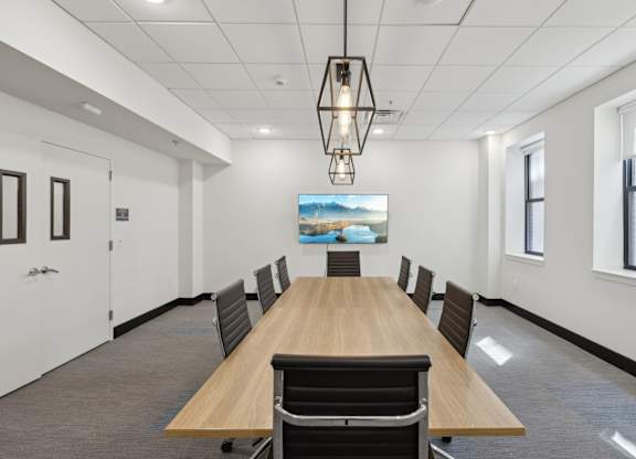 A conference room with a long table and chairs.