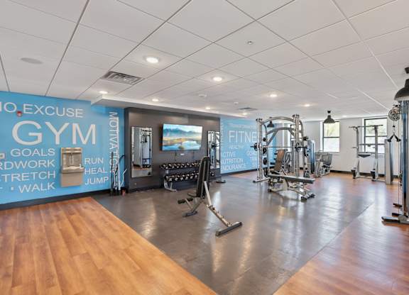 A gym with a variety of equipment and a sign that reads "No Excuse Gym".