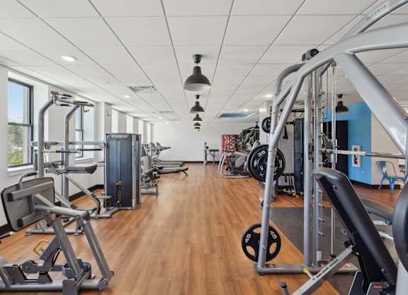 A gym with a variety of equipment including weights and machines.