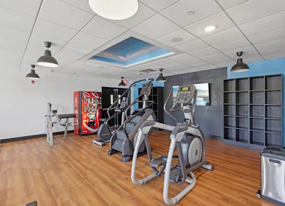 A gym with a variety of equipment including treadmills, stationary bikes, and weight machines.
