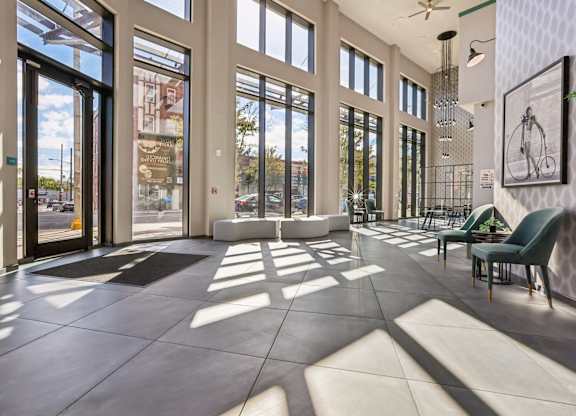 A sunny day at the lobby of a building with a bicycle hanging on the wall.