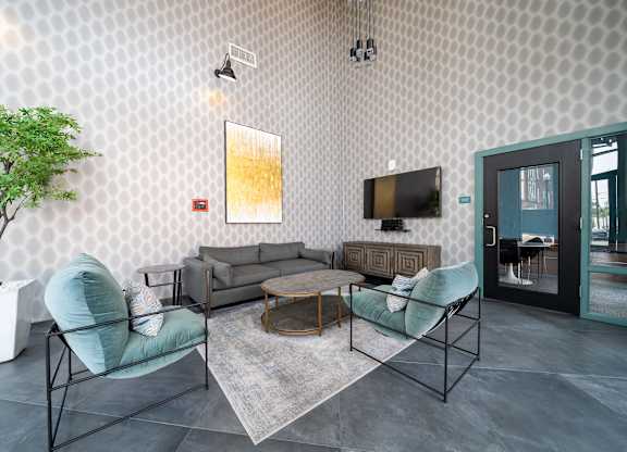 A living room with a grey sofa, a green chair and a television at Crossroads 389 Apartments, Hackensack 07601