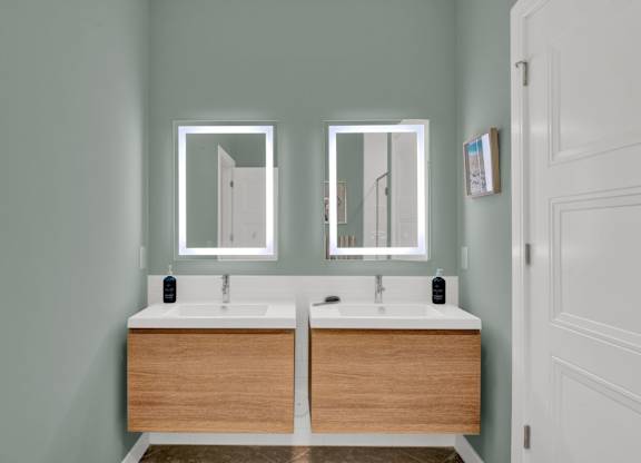 A bathroom with two sinks and two mirrors.
