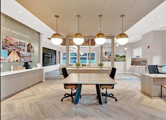 A modern office space with a long table and chairs in the center.