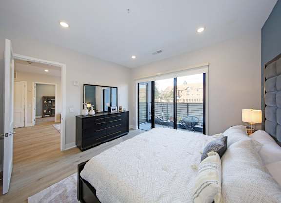A bedroom with a large bed and a dresser.