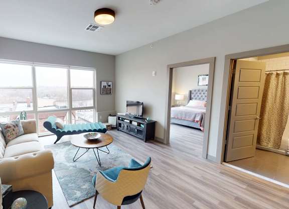 A living room with a white sofa and a blue chair at Crossroads 389 Apartments, New Jersey, 07601