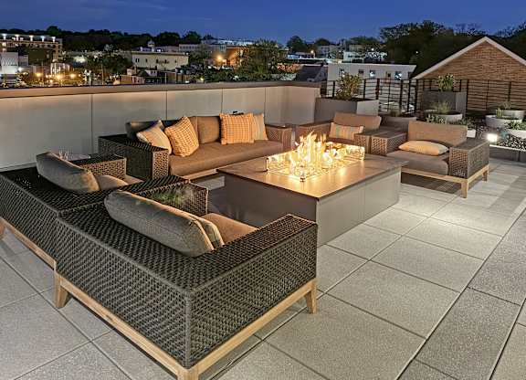 A rooftop patio with a couch and a firepit