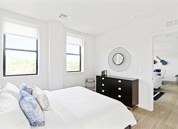 A white bedroom with a large bed and a window.