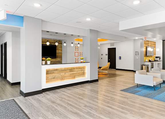 A reception area with a white reception desk and a blue rug.