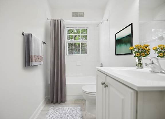 A bathroom with a toilet, sink, and shower.