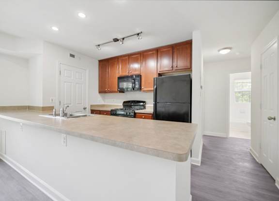 A kitchen with a white counter and brown cabinets.