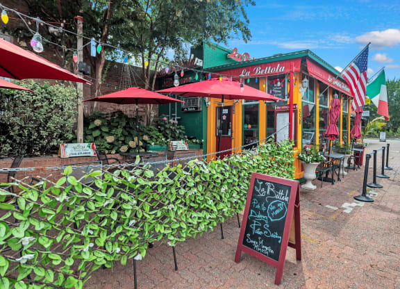 the outside of a restaurant with a chalkboard and umbrellas