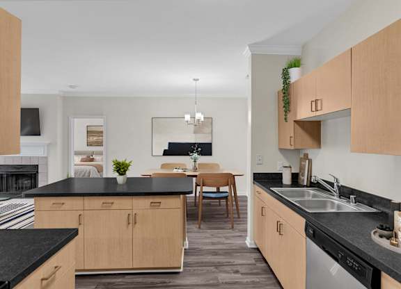 A kitchen with black countertops and wooden cabinets.