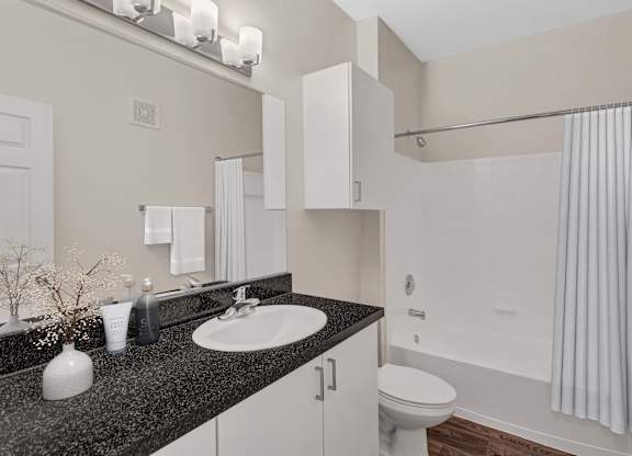 A bathroom with a sink, toilet, and shower.