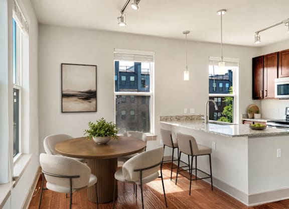 A modern kitchen with a dining table and chairs.