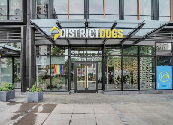 the front of a building with a sign that reads district dogs