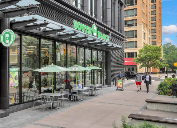 people walking down a sidewalk in front of a coffee shop