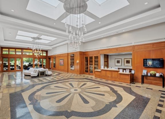 the lobby of a hotel with a rug and chandeliers