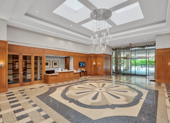 a large lobby with a geometric rug and a ceiling fan
