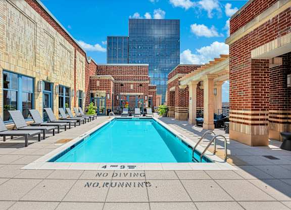 A pool surrounded by brick buildings with a sign that says