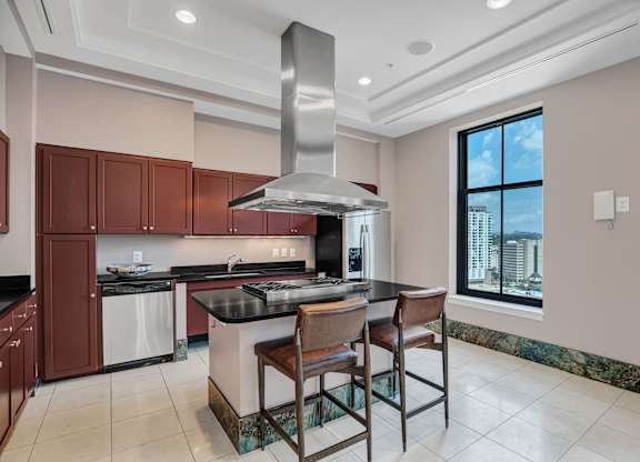 A modern kitchen with a large island and a stainless steel range hood.