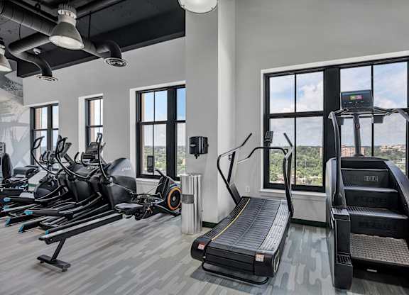 A gym with treadmills, exercise bikes, and elliptical machines.