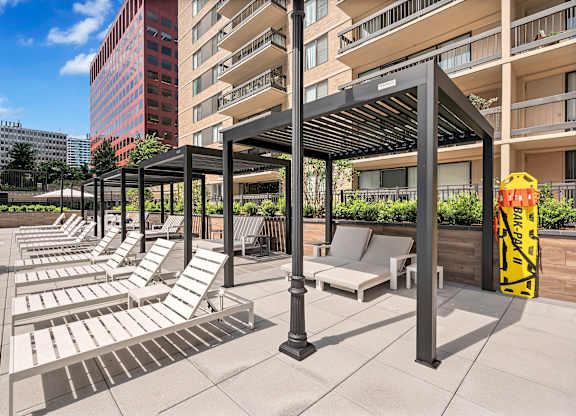A sunny day at the rooftop pool with lounge chairs and umbrellas.