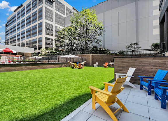A yellow chair is in the foreground of a patio with blue chairs and a table.