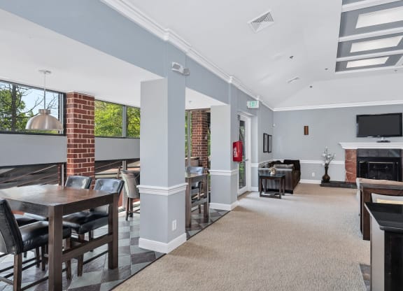 a common area with tables and chairs and a fireplace