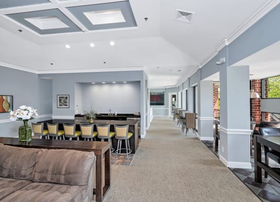 a room with a couch and chairs and a projector screen on the wall