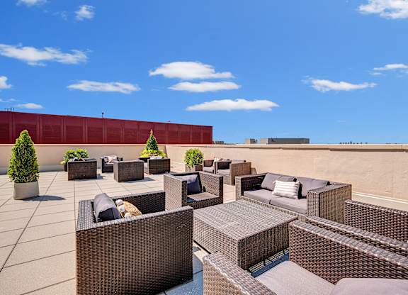 A patio with brown furniture and a red wall.