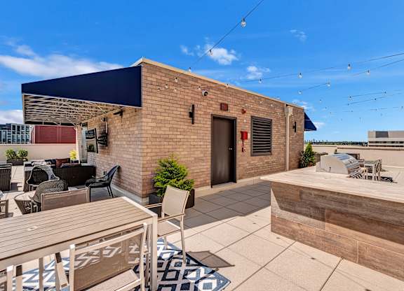 A patio with a table and chairs is surrounded by a brick building.