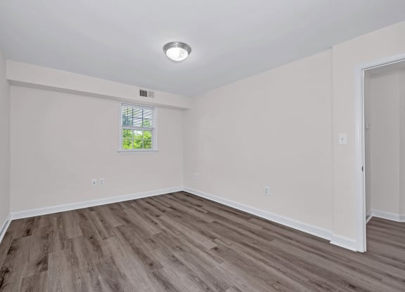 a bedroom with hardwood floors and white walls
