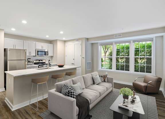 A modern living room with a kitchen area in the background.