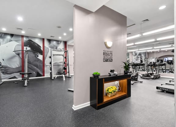 A gym with a variety of equipment and a sign that reads